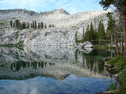 Alpine lake with granite peaks reflected in the still water